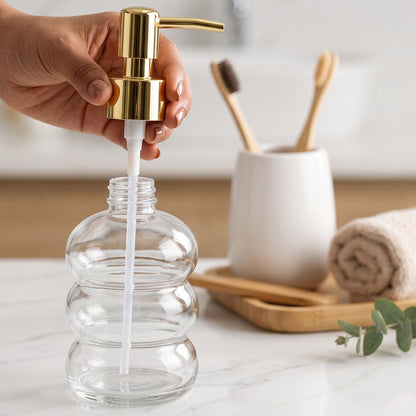 Clear glass liquid soap dispenser with a gold pump from Wukusy, showcasing a sleek and elegant design.