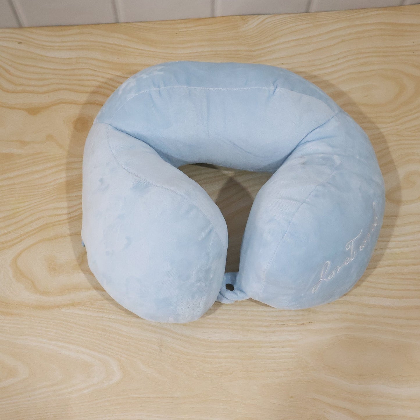 Blue plush U-shaped travel neck pillow by Wukusy providing soft head and neck support for comfortable journeys.