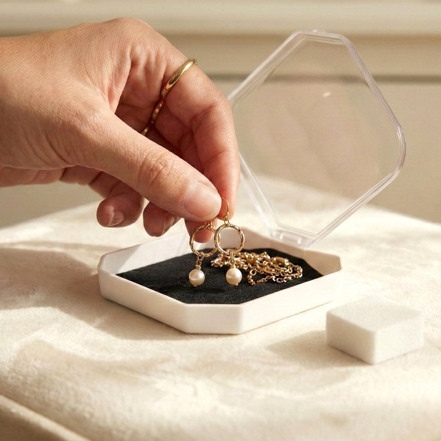 Wukusy jewelry display storage box with compartments for rings, earrings, and small jewelry items, shown with organized pieces inside.