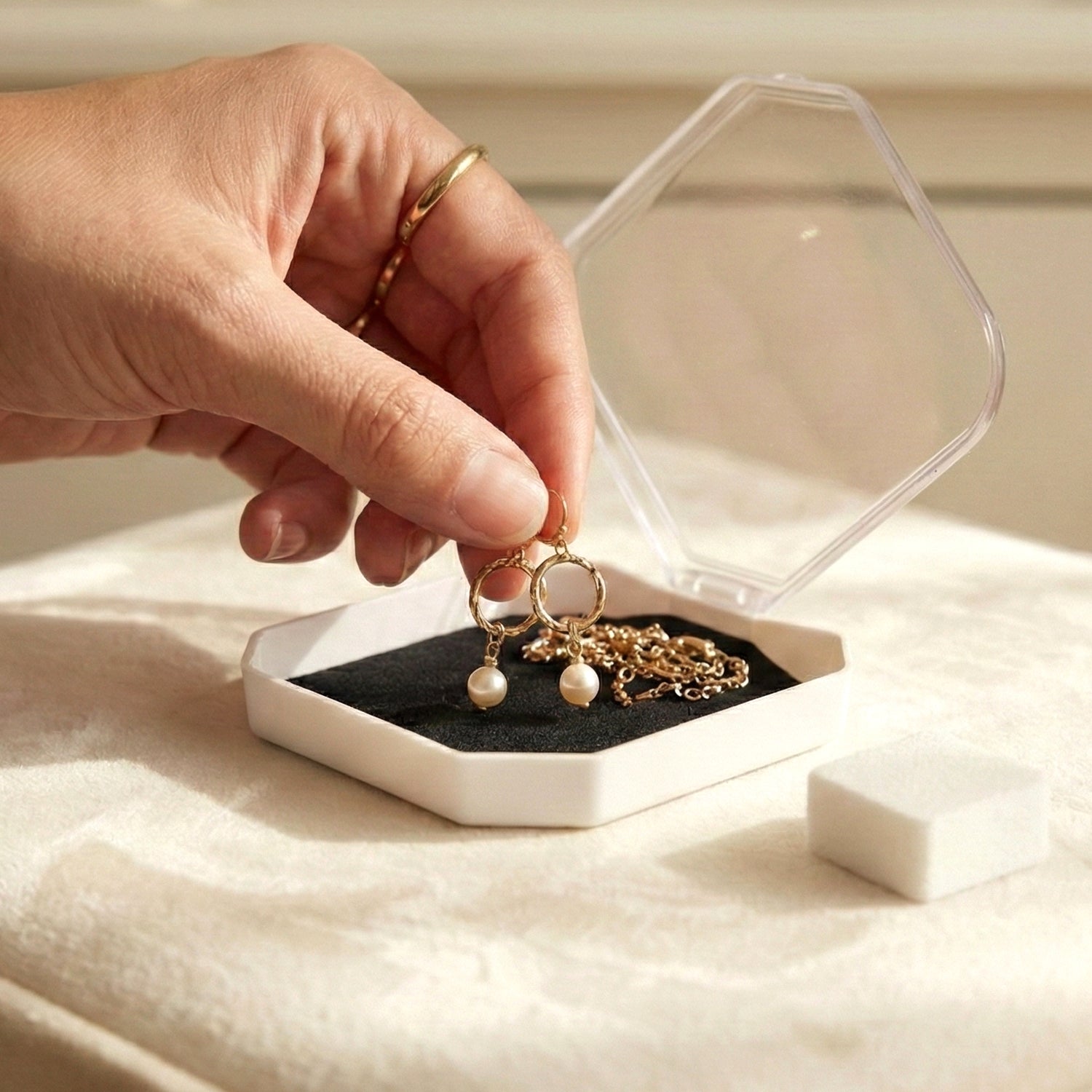 Wukusy jewelry display storage box with compartments for rings, earrings, and small jewelry items, shown with organized pieces inside.