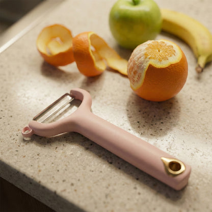 Wukusy handheld vegetable and fruit peeler showing a stainless steel blade and ergonomic handle for peeling produce.