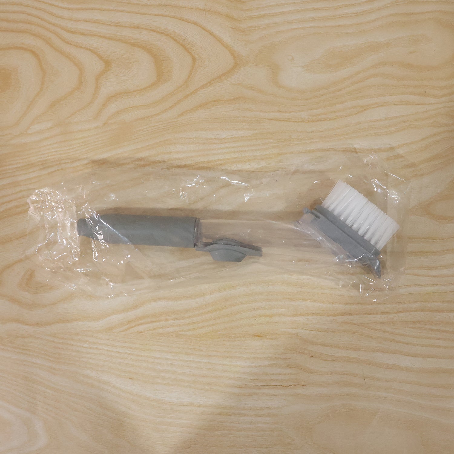 Refillable soap dispensing dish scrub brush by Wukusy with ergonomic handle for kitchen cleaning and scrubbing dishes.