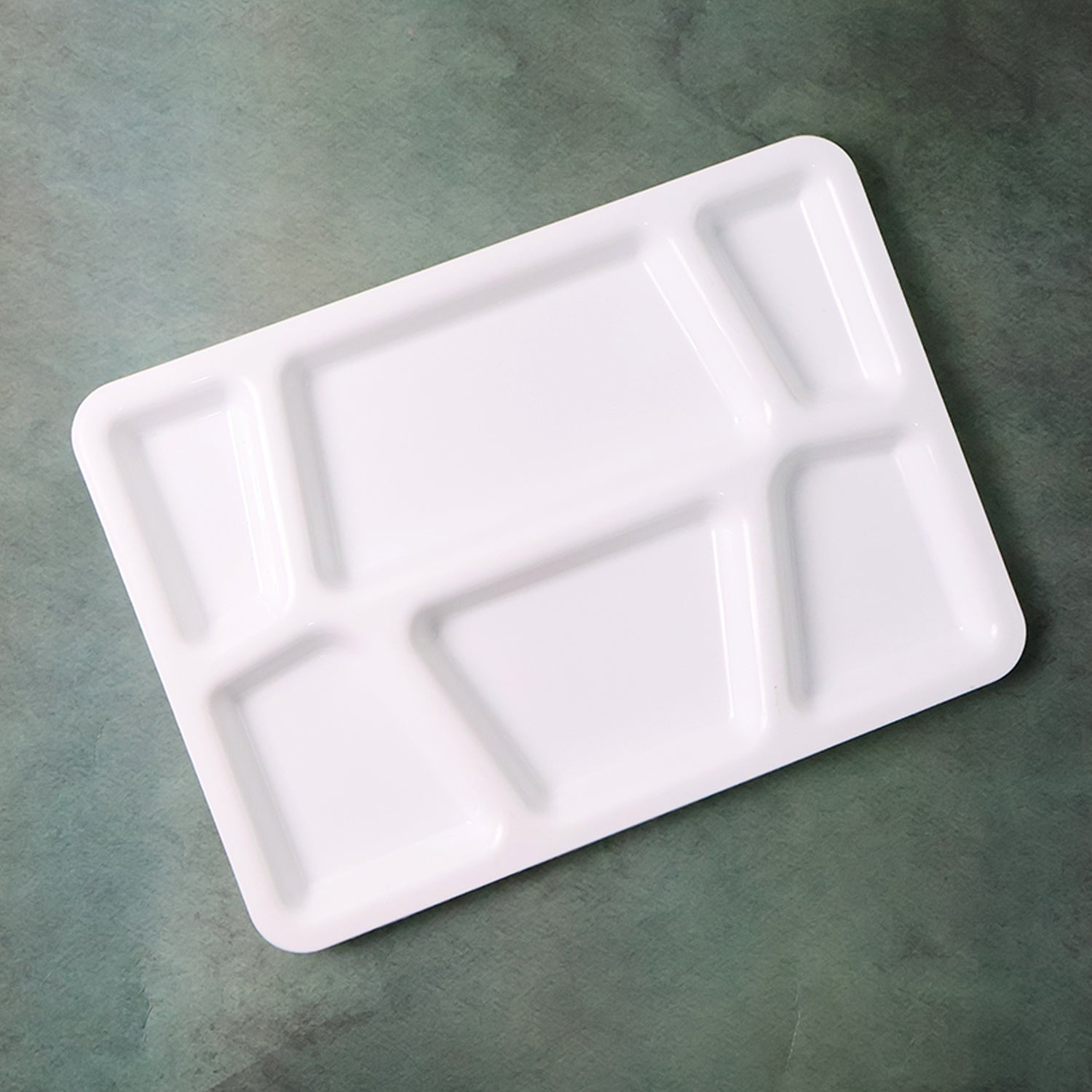 White plastic multi-compartment rectangular meal serving tray with divided sections for convenient food presentation.