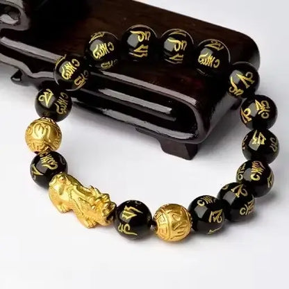 Ekom black and golden lucky bracelet with Pixiu charm, designed for health and household wellness, featuring intricate details.
