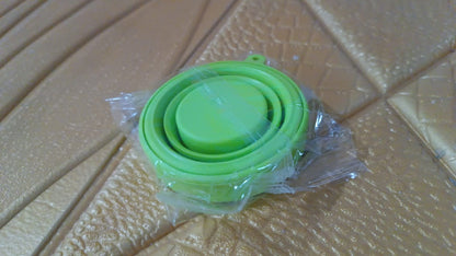 Round silicone foldable travel mug with lid by Wukusy, showing the compact, foldable design and transparent glass material.