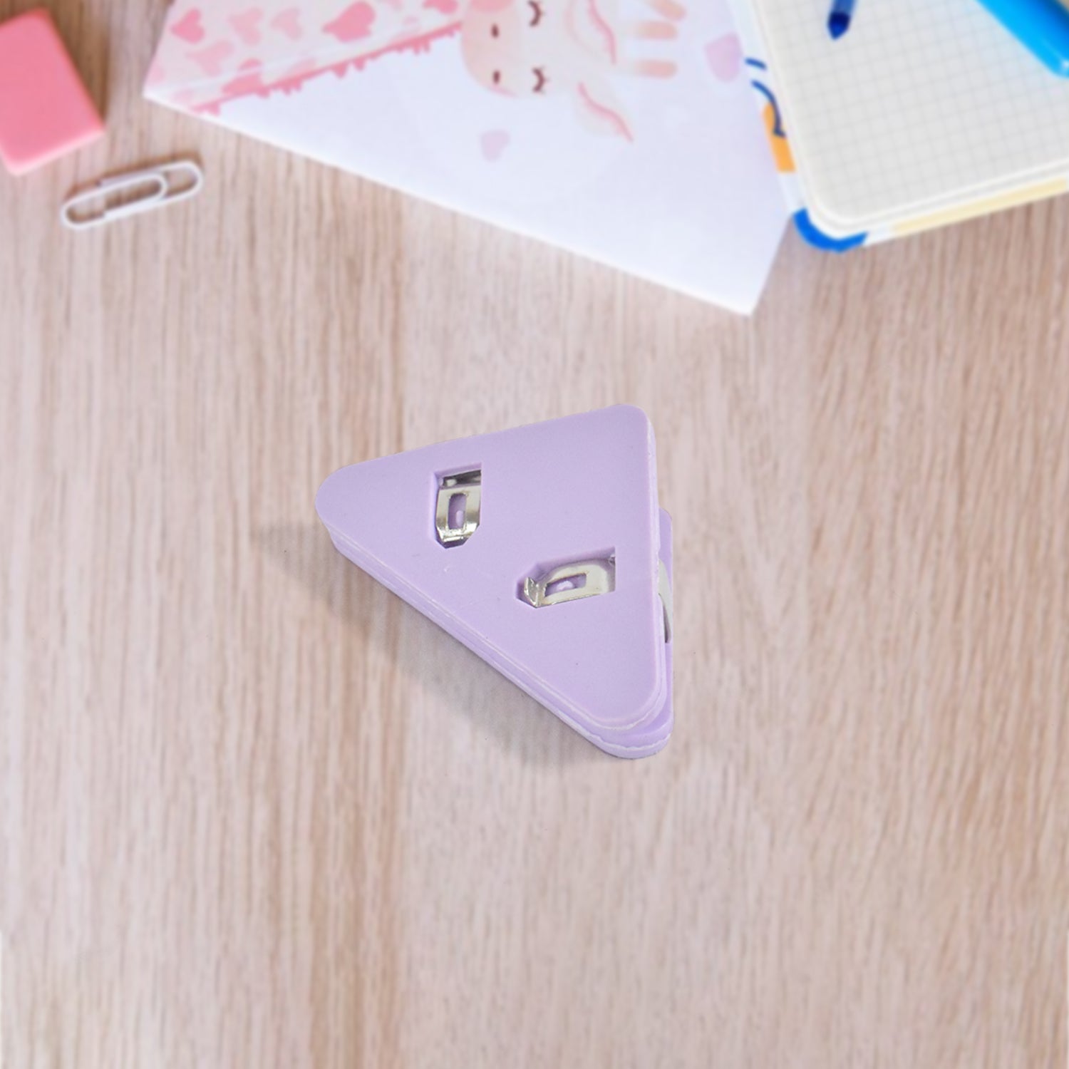 Small Wukusy triangle paper clip for securing paper documents, ideal for office use, shown holding papers in a corner.