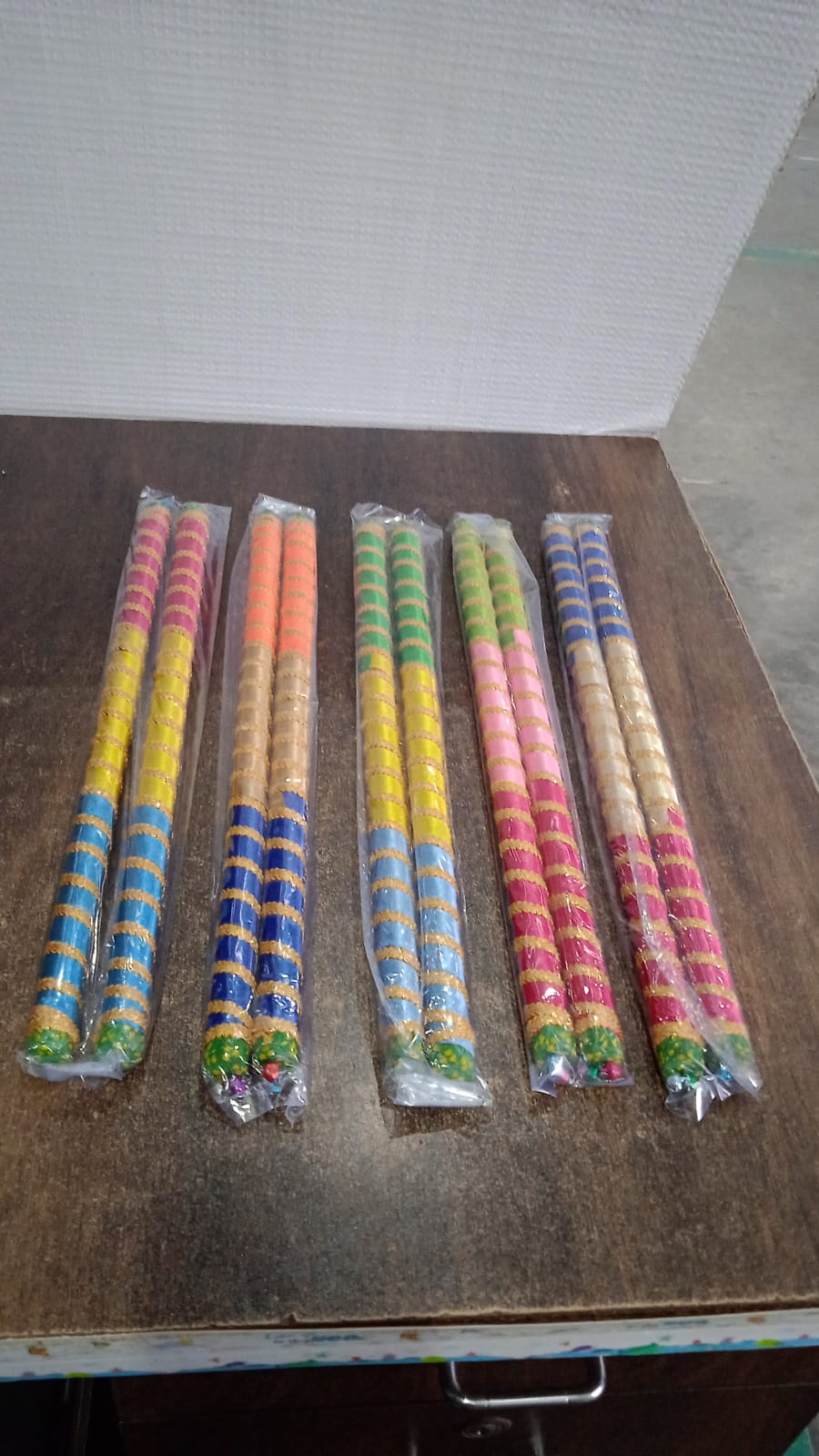 Pair of traditional decorative Dandiya sticks for Navratri Garba by Wukusy, featuring colorful, intricately designed wooden sticks.