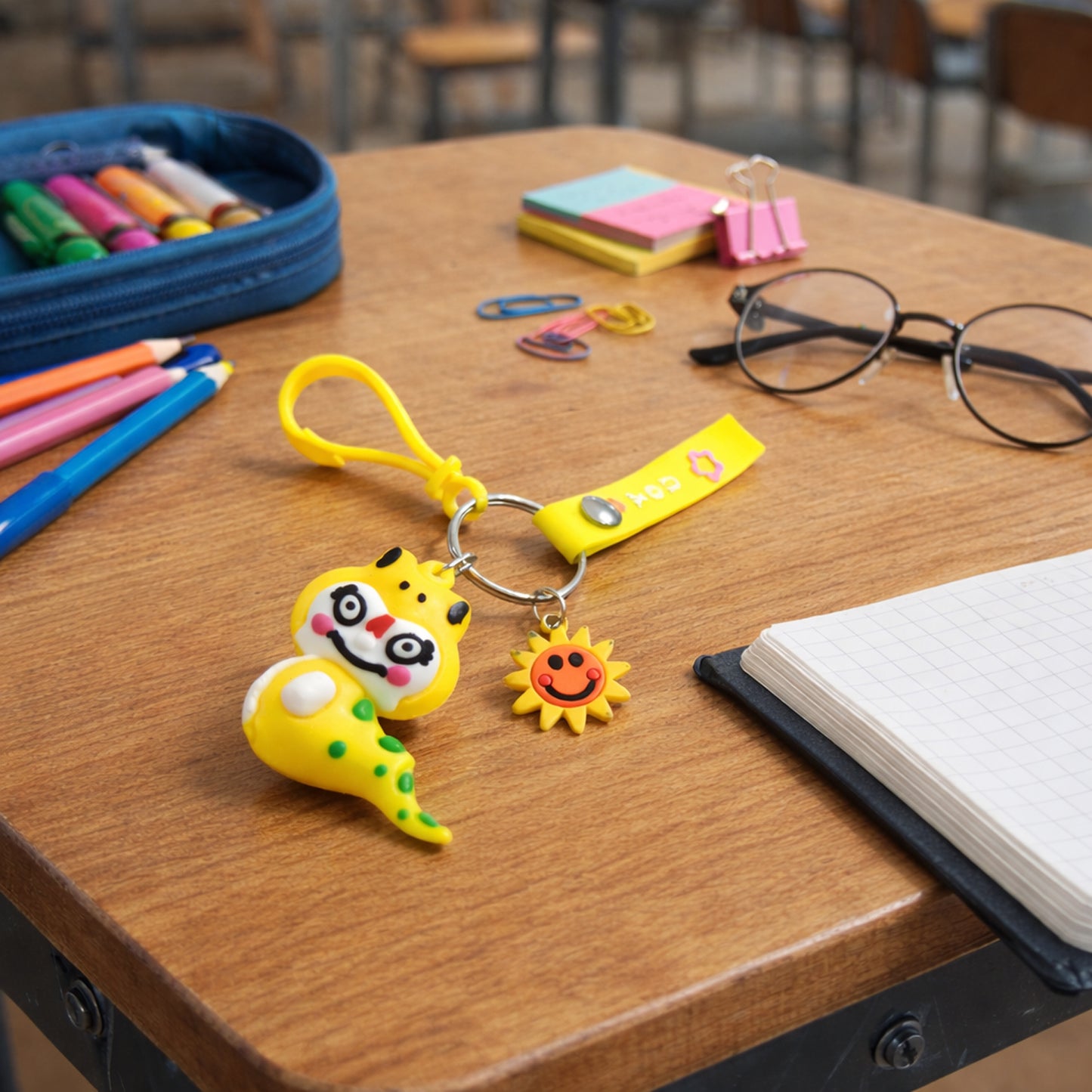 Cute cartoon dinosaur keychain with strap and decorative charm, featuring vibrant colors and detailed dinosaur design.