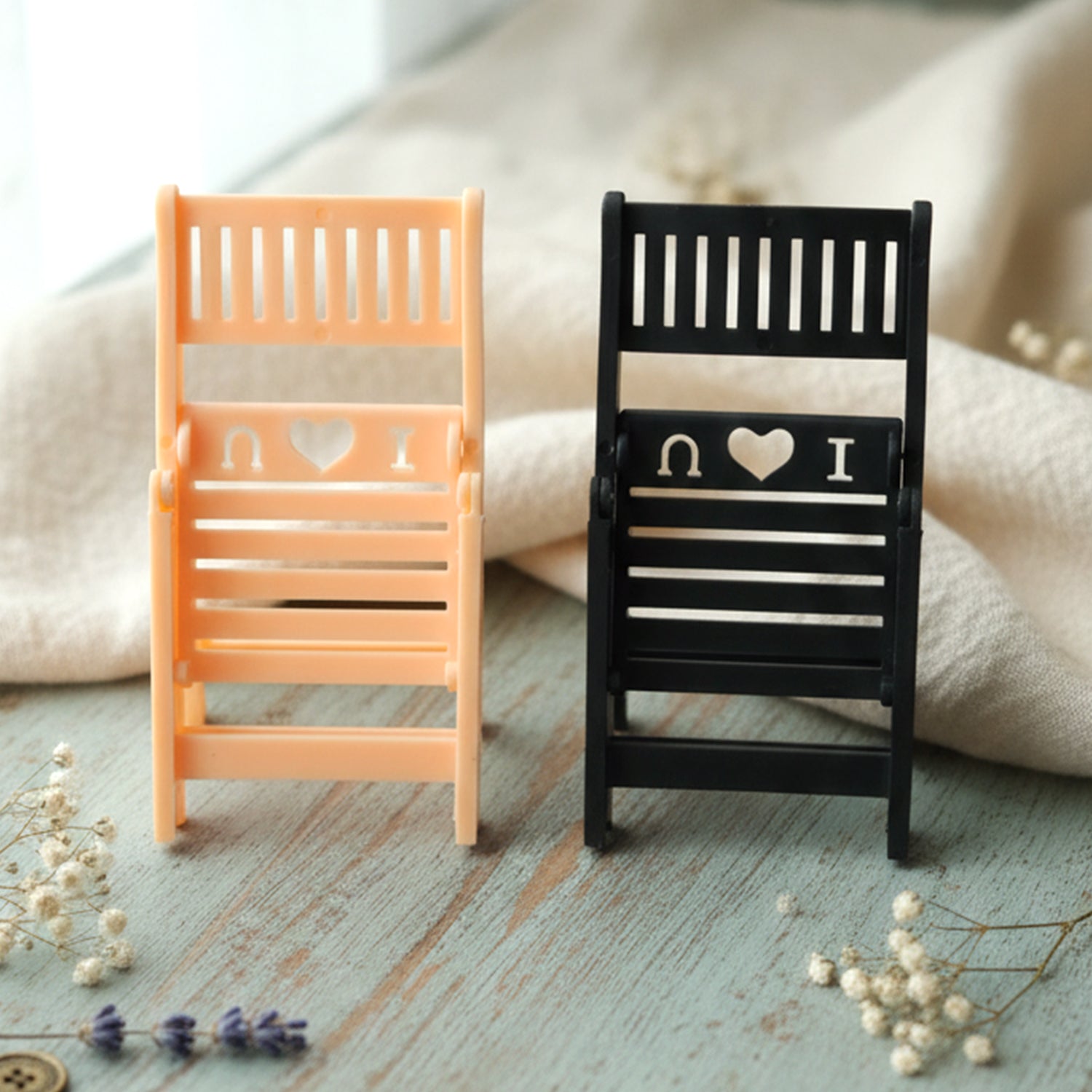 Wukusy mini chair-shaped mobile stand holder, black plastic, designed to hold smartphones securely on a flat surface.