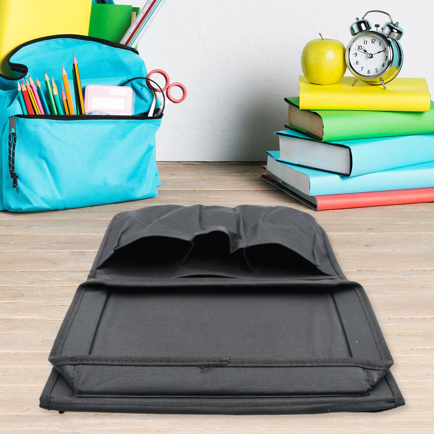 Black Wukusy sofa arm rest hanging storage bag with multiple compartments for magazines, iPads, and books.