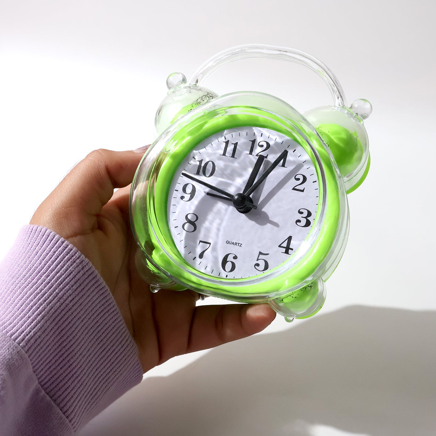 Wukusy classic quartz alarm clock with white dial, black numerals, and silver casing, placed on a wooden bedside table.