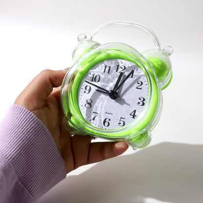 Wukusy classic quartz alarm clock with white dial, black numerals, and silver casing, placed on a wooden bedside table.