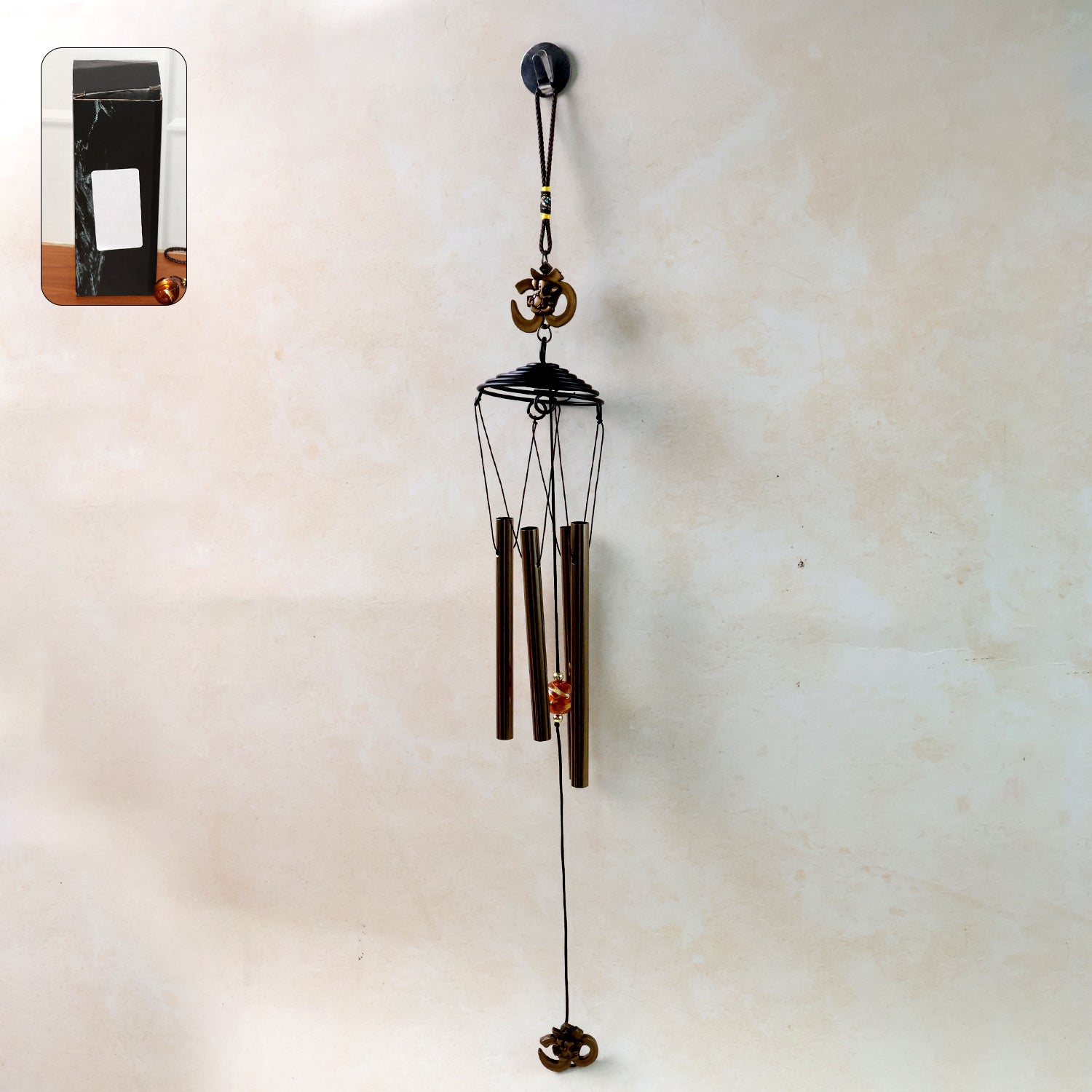 Metal wind chime with Om symbol by Wukusy, featuring hanging metal tubes and decorative Om design for peaceful outdoor decor.