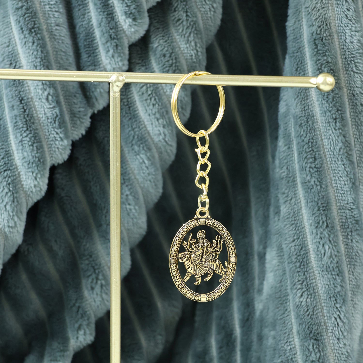 Golden Maa Durga oval frame keychain by Wukusy featuring a detailed image of the goddess on a compact keychain.