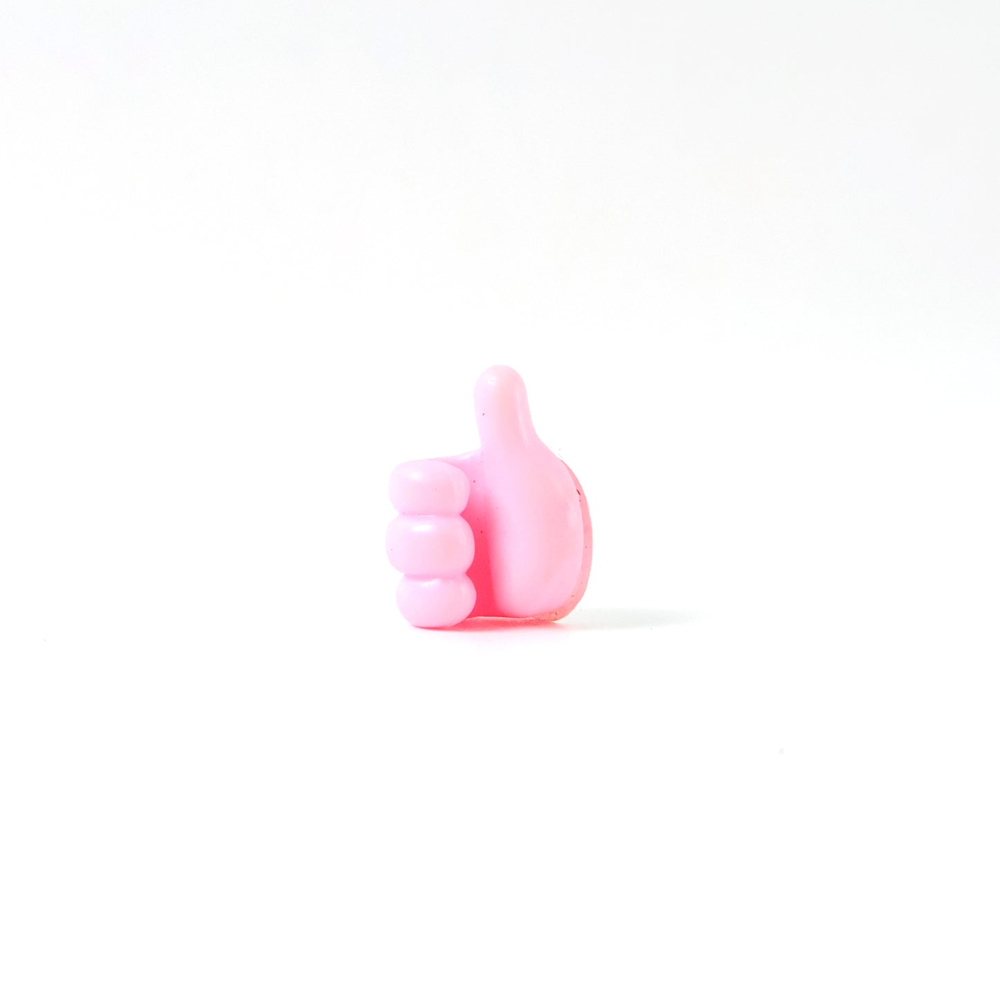 Pink multifunctional hand-shaped wall clip hanger by Wukusy for keys, cables, and small accessories, mounted on a wall.