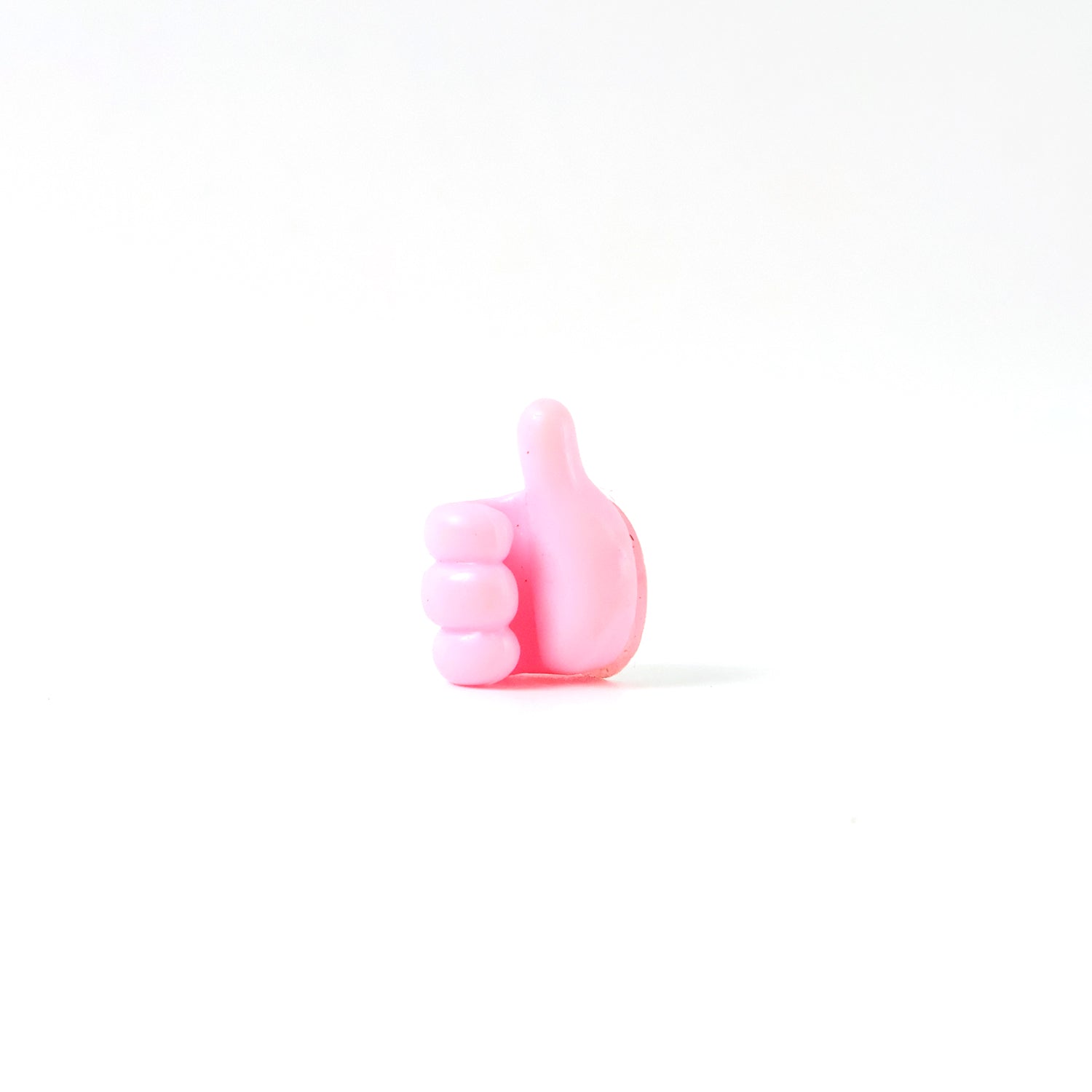 Pink multifunctional hand-shaped wall clip hanger by Wukusy for keys, cables, and small accessories, mounted on a wall.