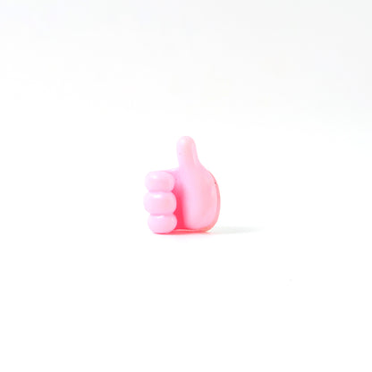 Pink multifunctional hand-shaped wall clip hanger by Wukusy for keys, cables, and small accessories, mounted on a wall.