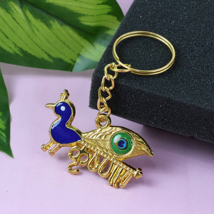 Golden Krishna peacock design keychain by Wukusy with intricate peacock and Krishna motifs, showing detailed metal craftsmanship.