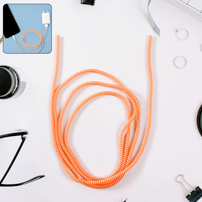 Flexible spiral cable protector sleeve by Wukusy for mobile accessories, shown coiled around a charging cable.