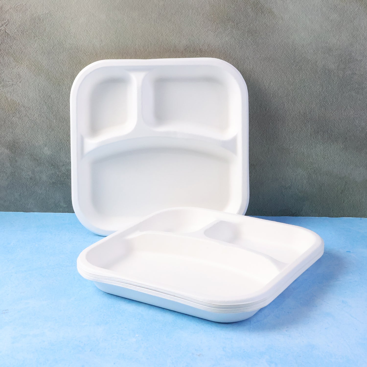 Wukusy compostable bagasse 3-compartment square meal plate with sections for different foods, ideal for eco-friendly dining.