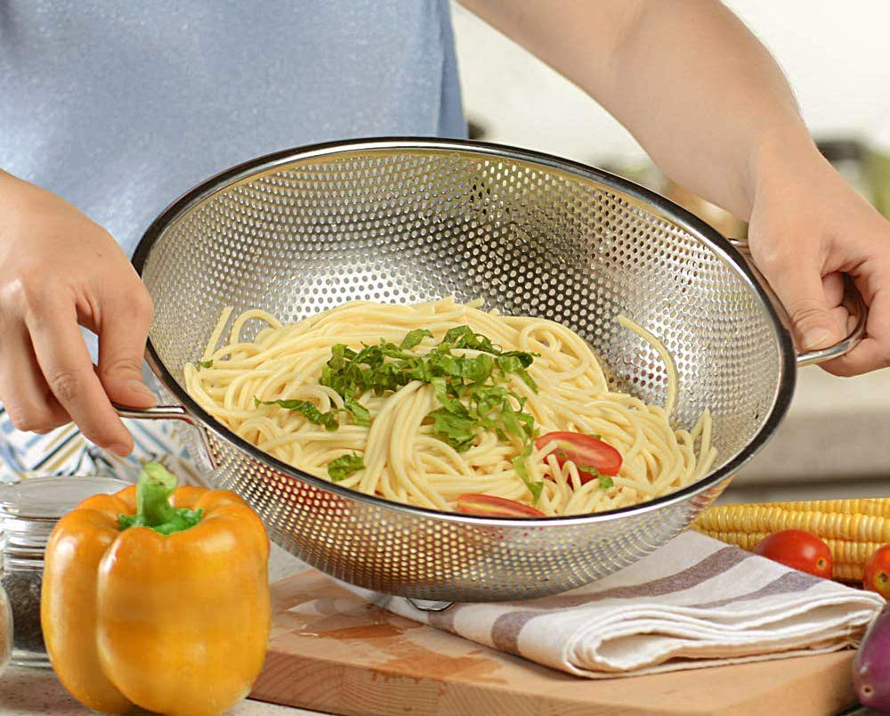 Stainless steel Drpshippr kitchen colander strainer with handle, perfect for draining pasta and vegetables. Monsoon Arrivals collection.