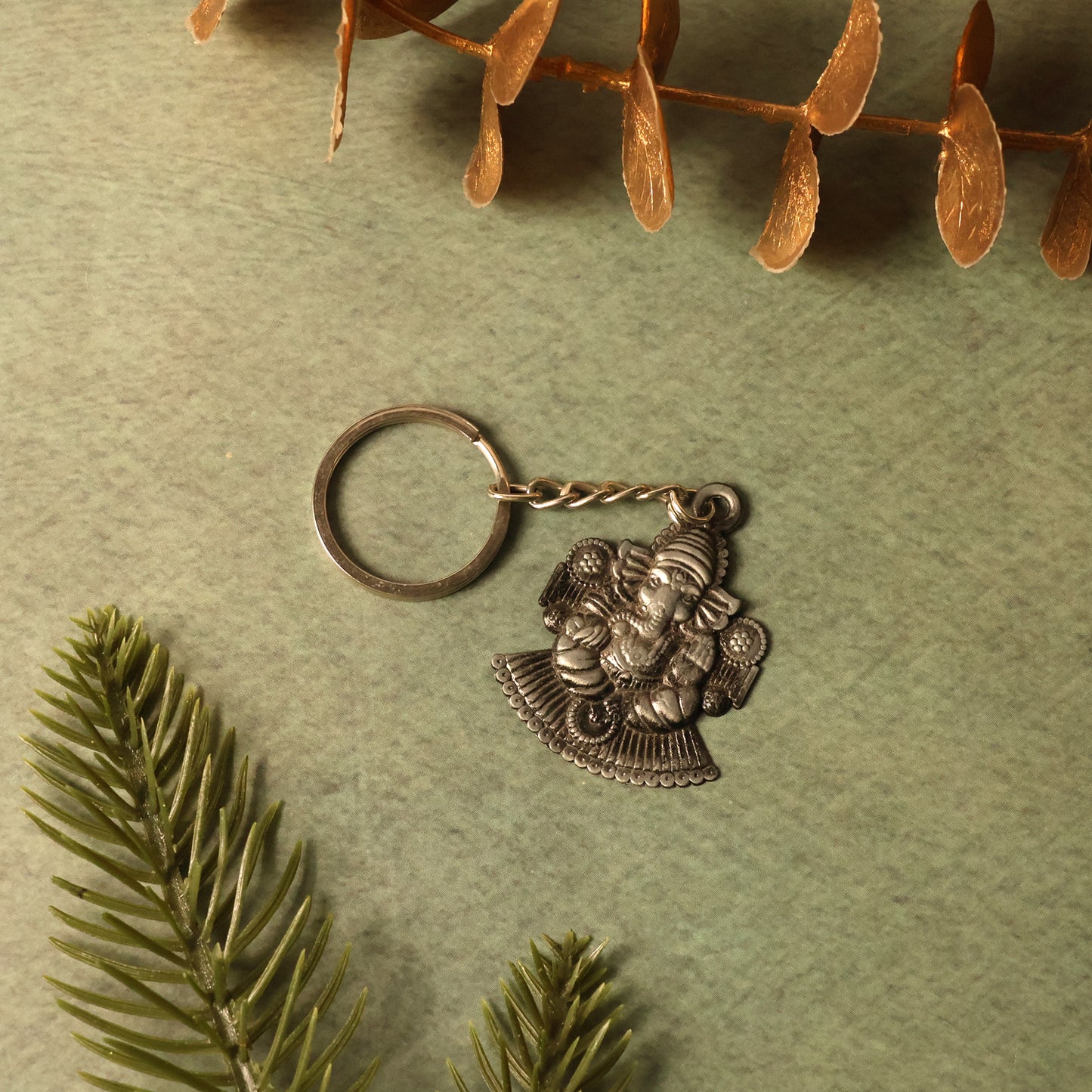 Silver Lord Ganesha sitting design keychain by Wukusy, featuring intricate craftsmanship and a detailed depiction of Lord Ganesha.