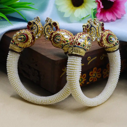 Ekom traditional peacock design pearl bangles for women featuring intricate peacock motifs and white pearls on gold-toned bangles.