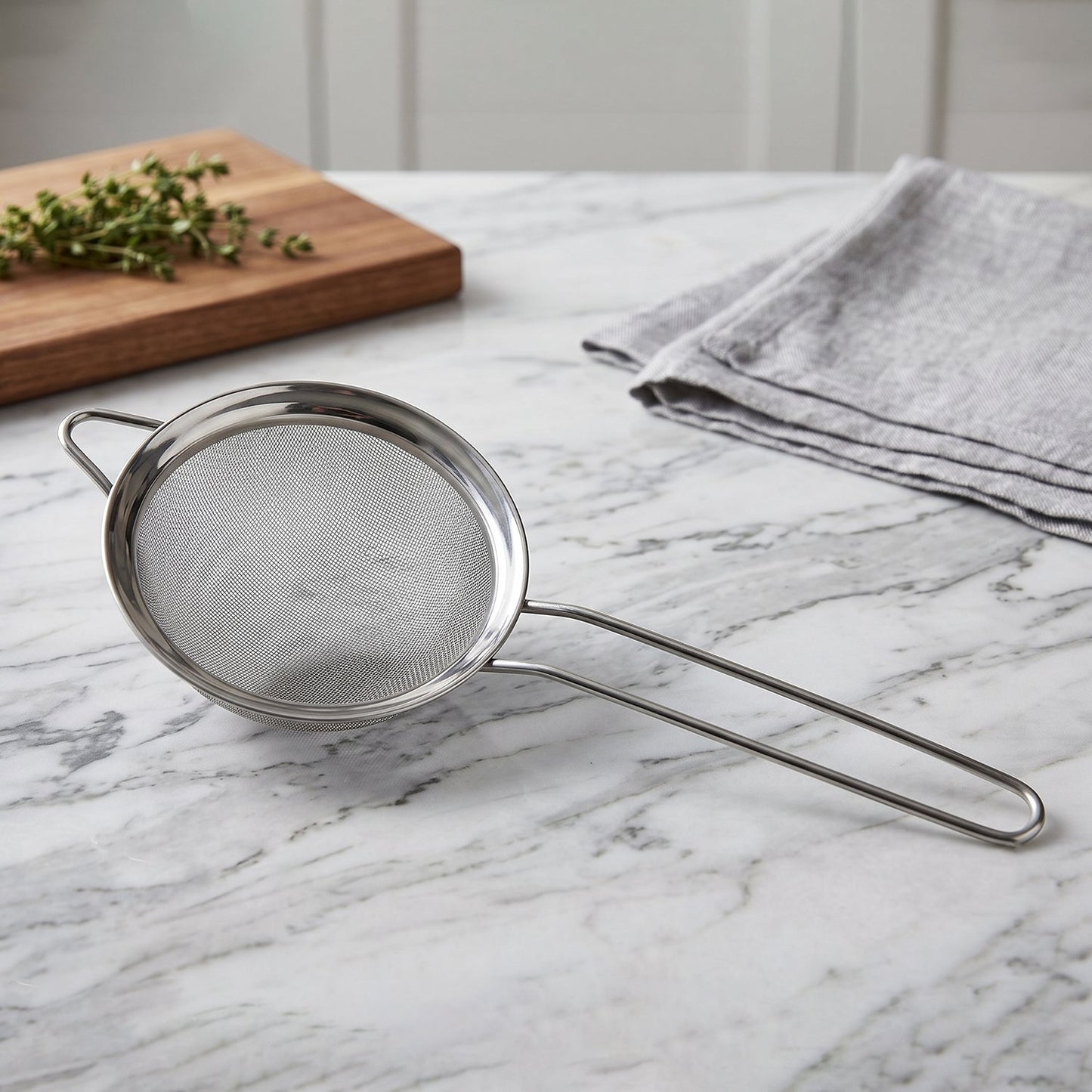 Wukusy stainless steel tea strainer with fine mesh and long handle for brewing and filtering tea in the kitchen.