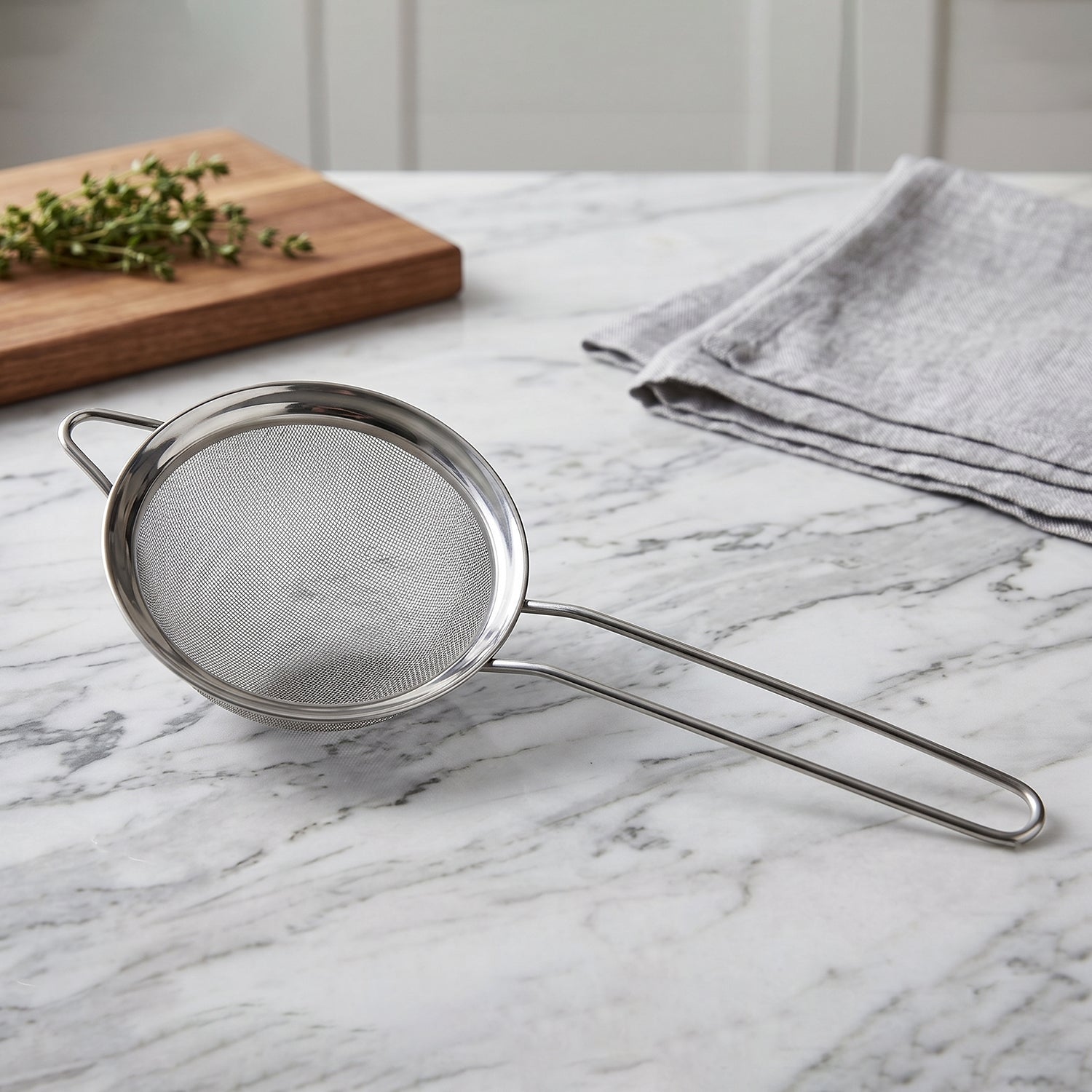 Wukusy stainless steel tea strainer with fine mesh and long handle for brewing and filtering tea in the kitchen.