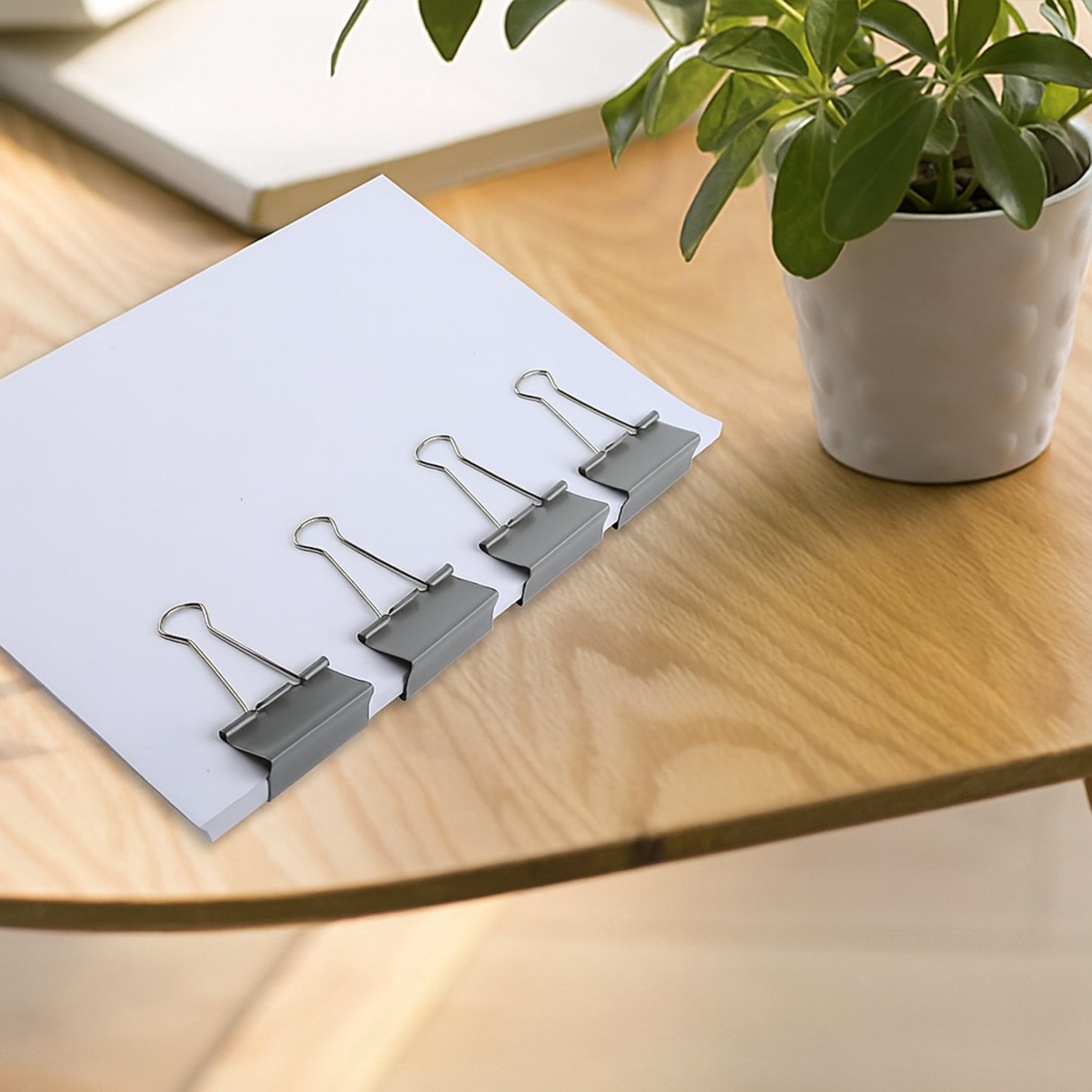 Heavy-duty Wukusy foldback binder clip clipped onto paper, showcasing durable metal construction for home improvement tasks.