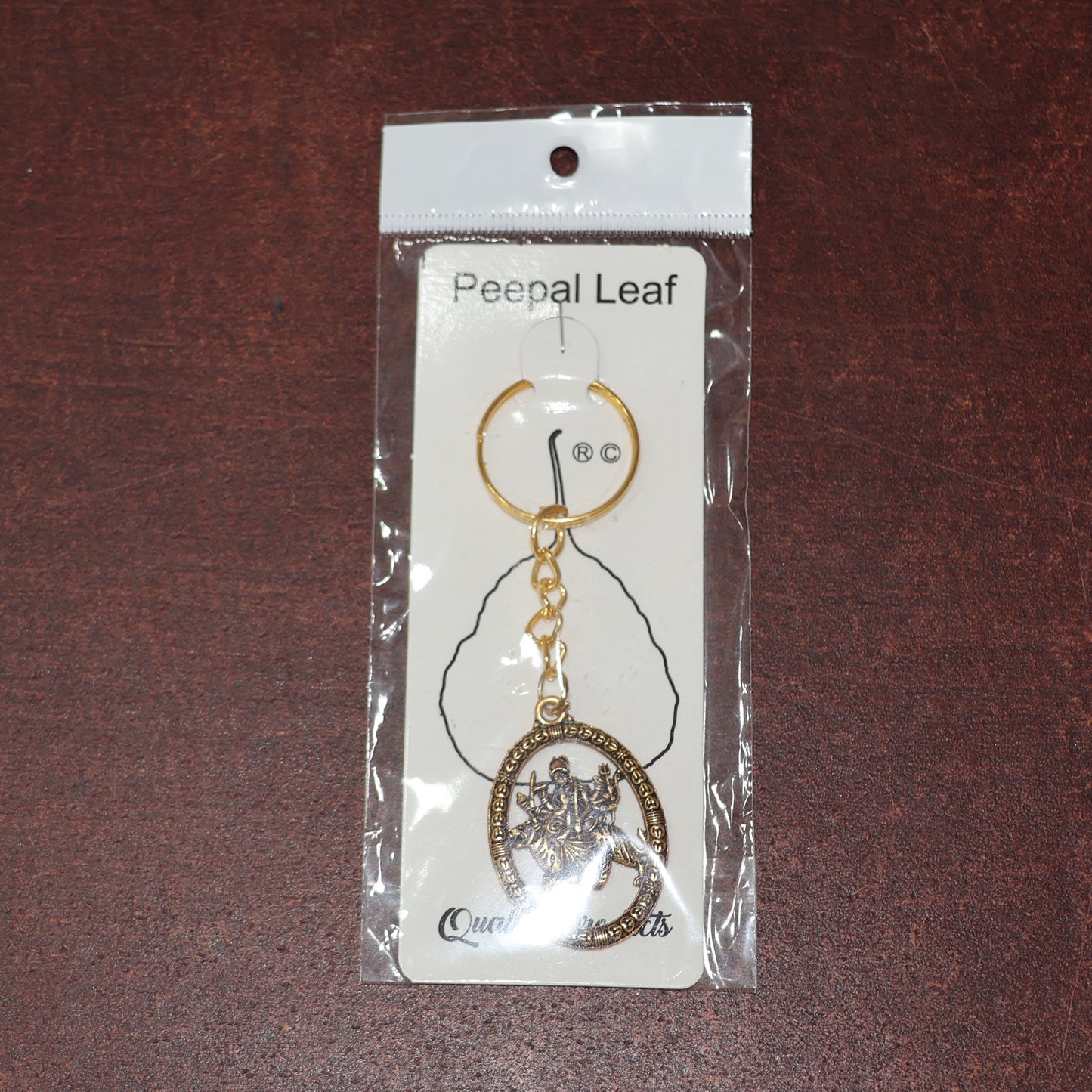 Golden Maa Durga oval keychain by Wukusy featuring intricate design, perfect for adding spiritual charm to keys or bags.