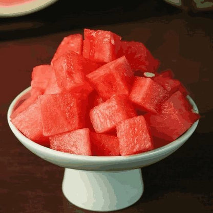 Close-up of 205 Ruby Watermelon Basil Seeds in a small clear container, showcasing their vibrant red and black seed details.