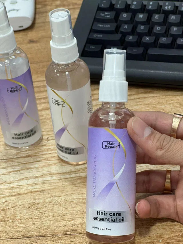 Hair repair essential oil from 16182, shown in a 100ml bottle, with a hair curler nearby on a light background.