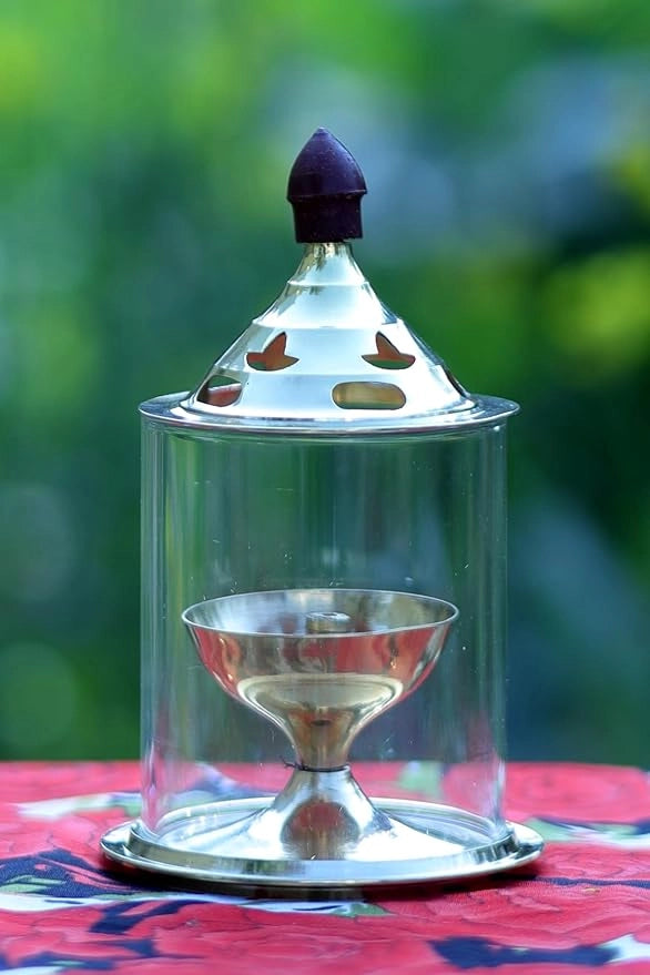 Brass and glass Akhand Deep Diya with cover for puja, traditional oil lamp for spiritual rituals and prayer ceremonies.