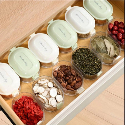 Four-layer transparent spice storage jars with labeled compartments for organized kitchen spice storage.