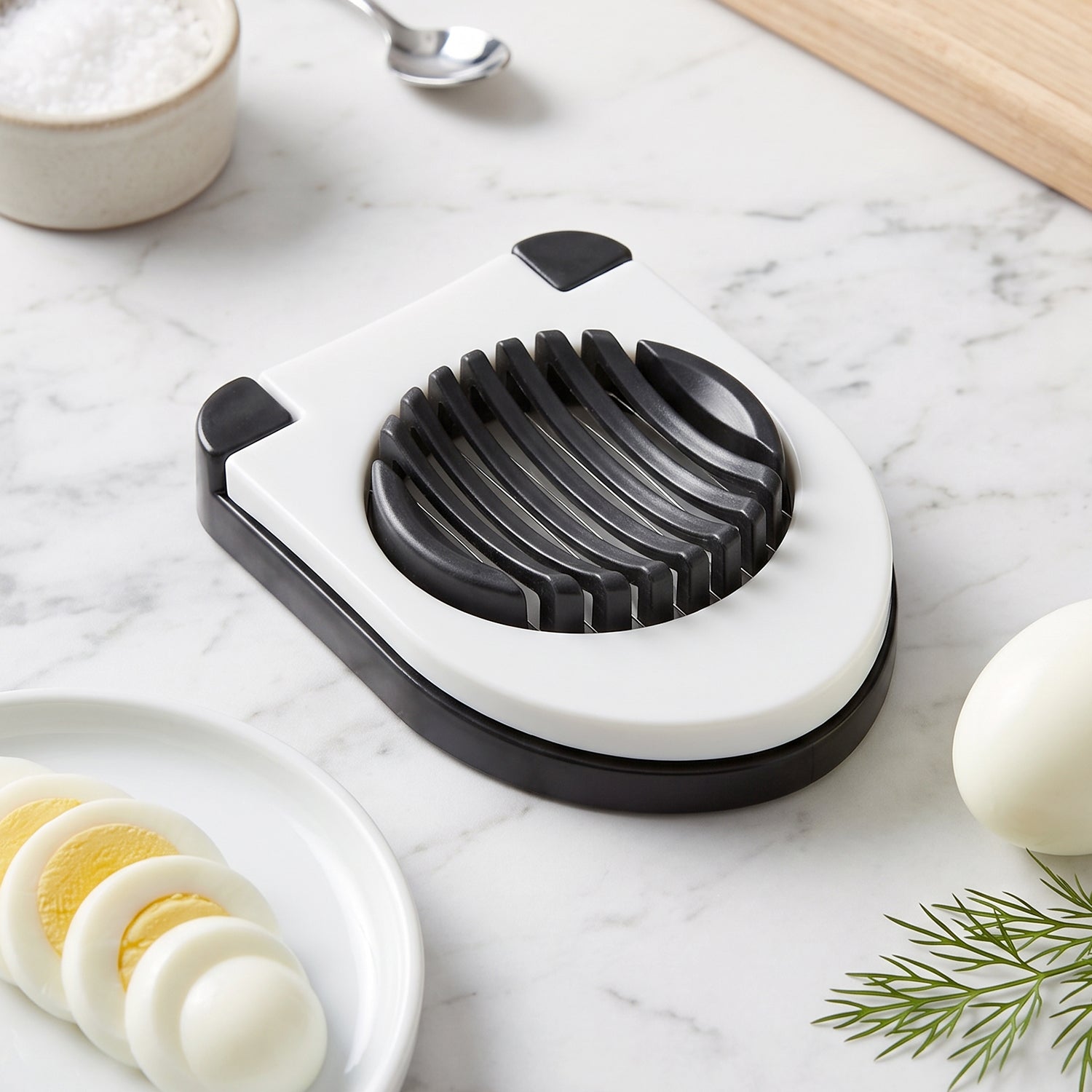 Wukusy stainless steel egg cutter slicer with wire cutting tool for boiled eggs, shown on a kitchen countertop.