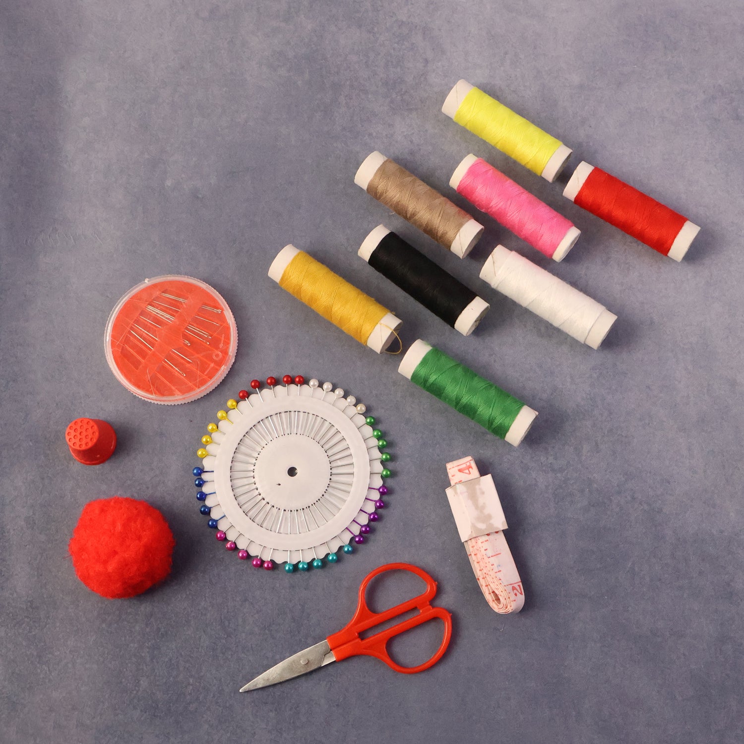 Wukusy complete sewing and stitching kit with threads, needles, and accessories for all sewing projects, laid out on a flat surface.