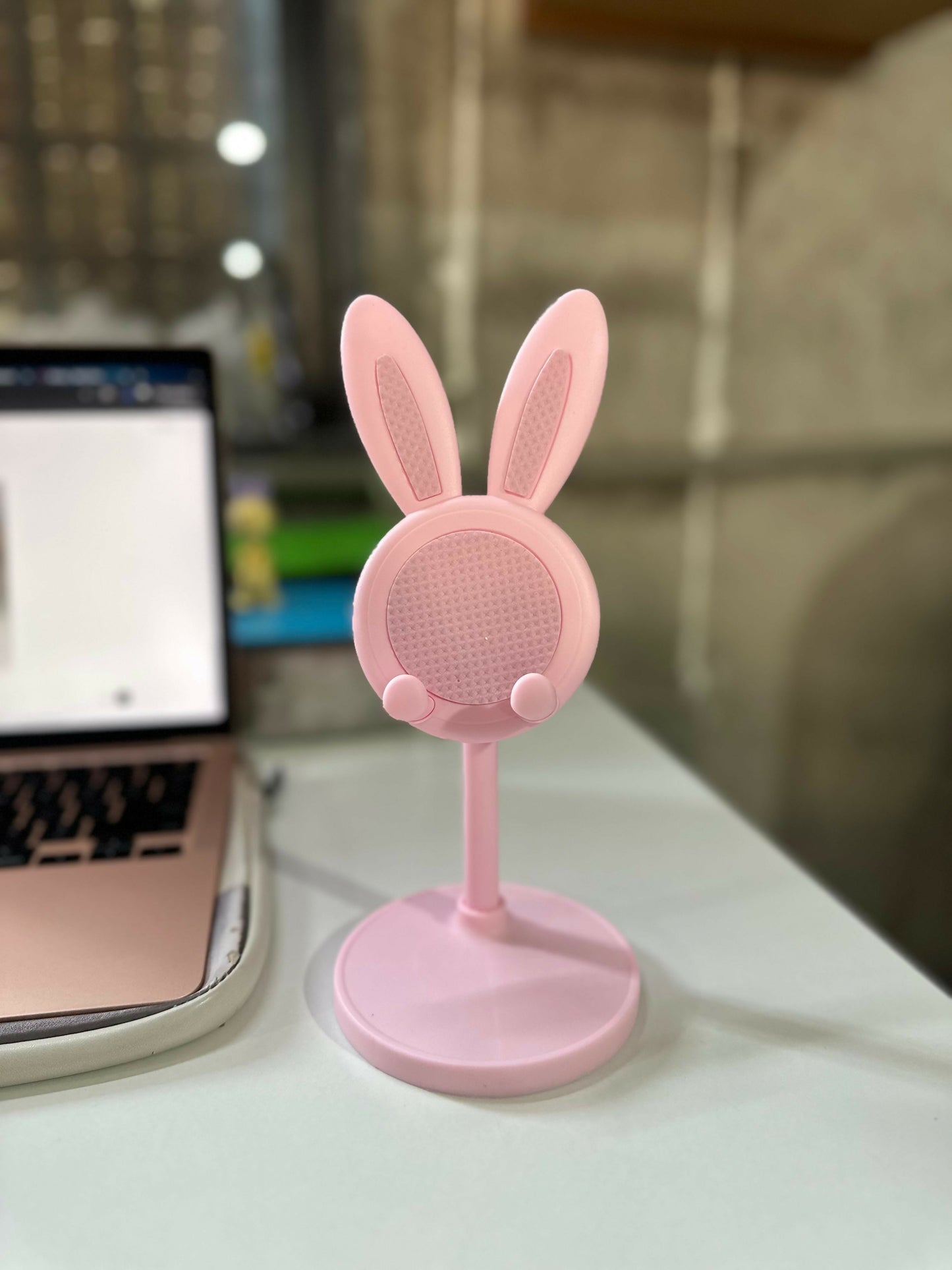 Wukusy cute bunny mobile stand holder on a desk, perfect for kids' study tables, with colorful bunny design and adjustable support
