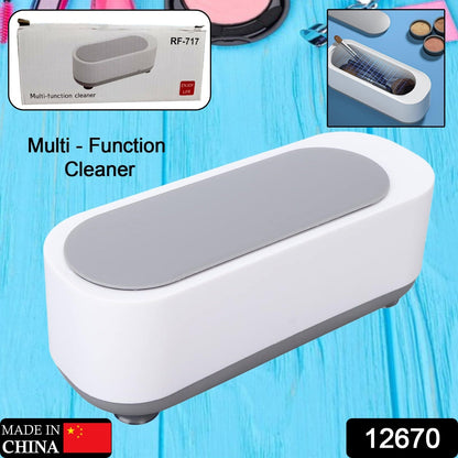 Wukusy ultrasonic jewelry cleaner with compact design, showing a silver ring, glasses, and coins inside the cleaning chamber.