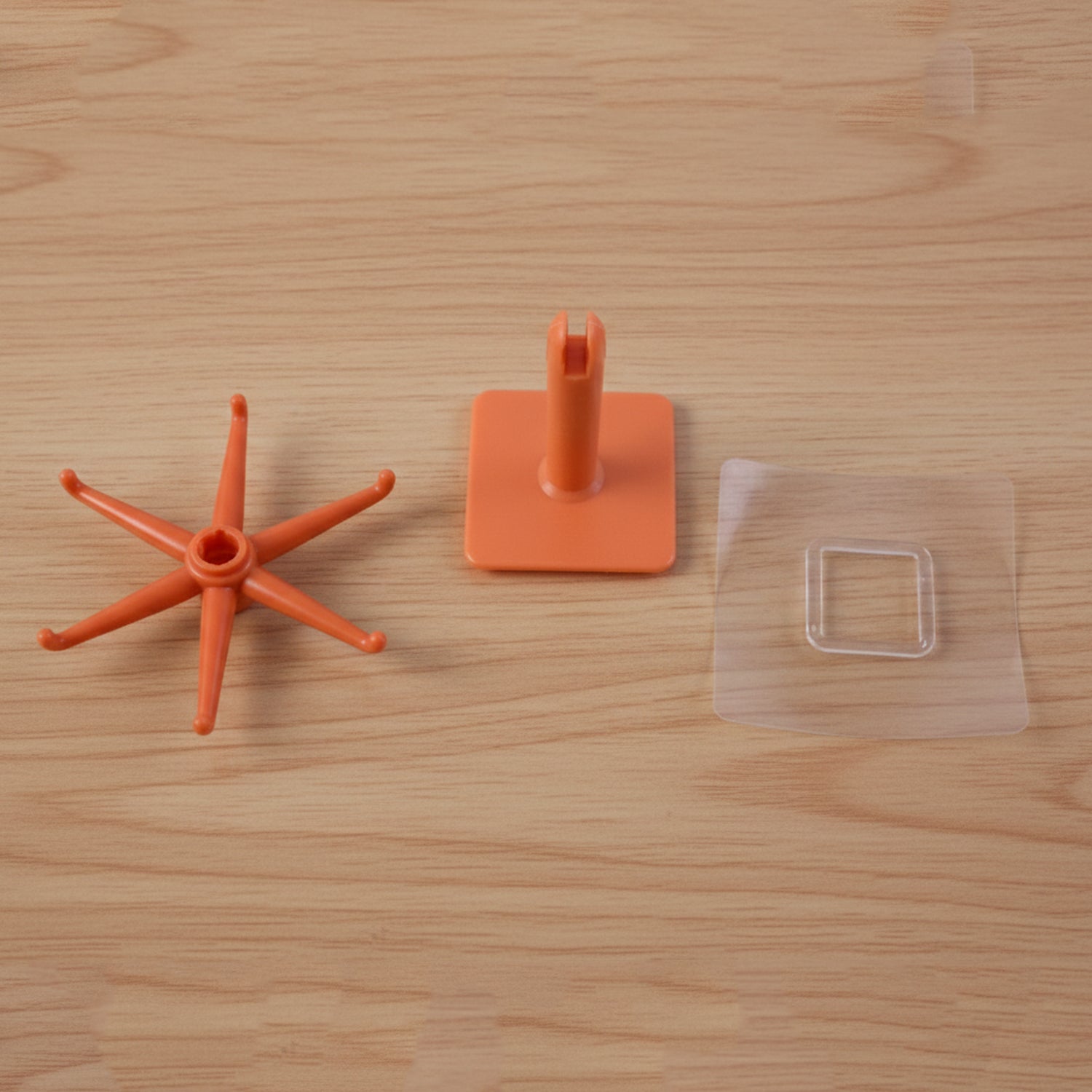 Wukusy orange 360 rotating wall-mounted kitchen utensil hook stand on a kitchen wall, holding various utensils.