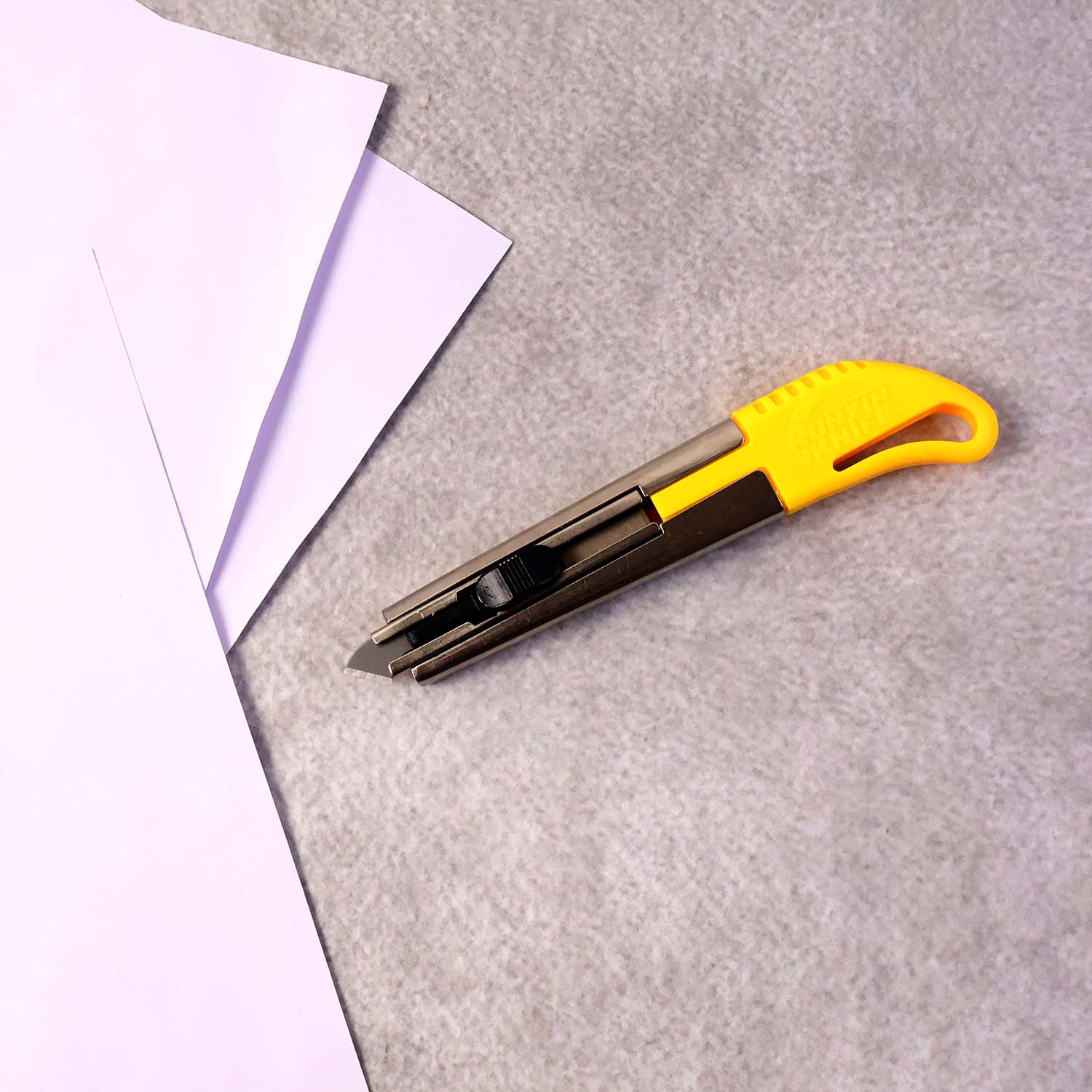 Wukusy heavy-duty stainless steel utility cutter knife with ergonomic handle and two extra blades, ideal for office and craft use.
