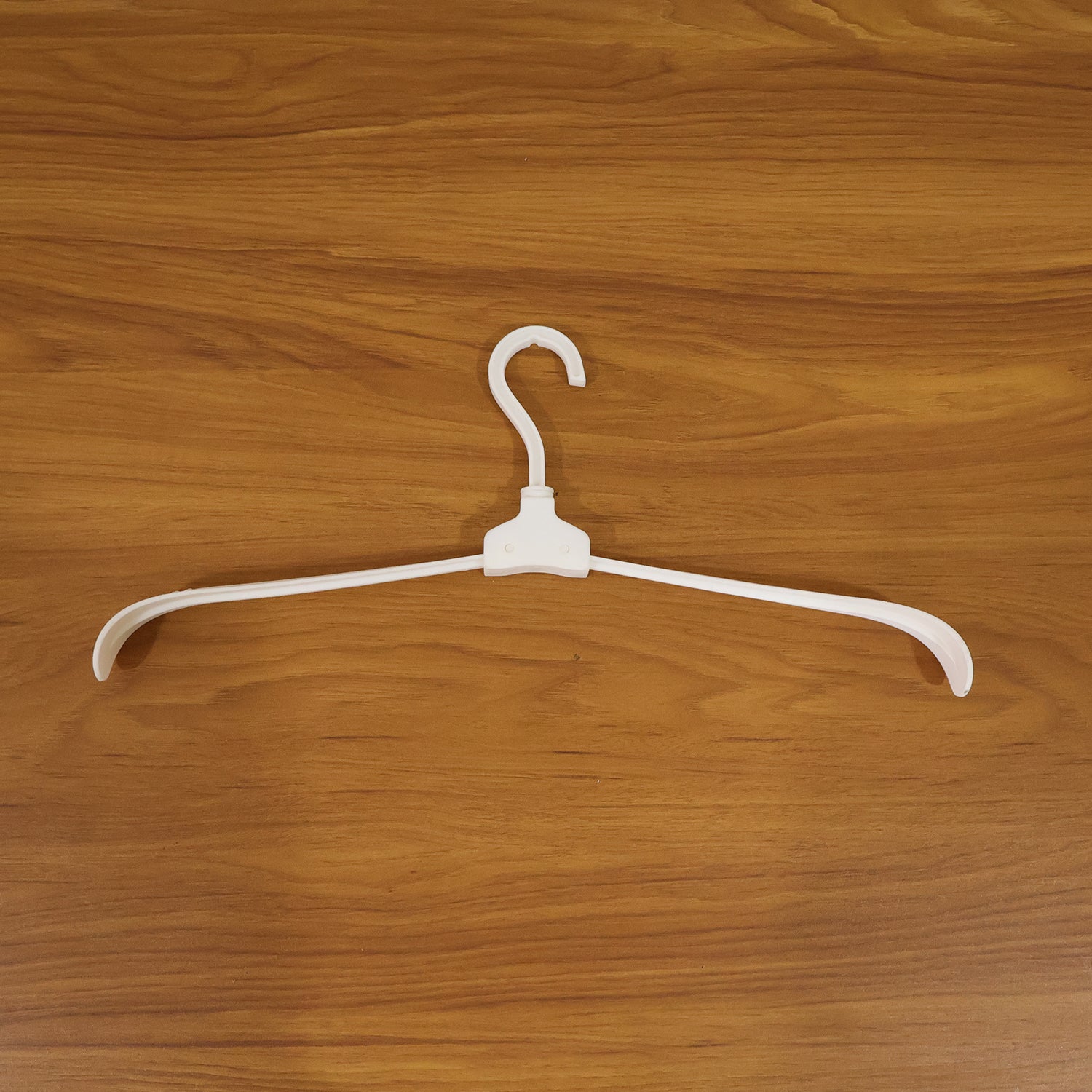 Wukusy premium foldable plastic clothes hanger hanging on a closet rod, showcasing its compact, lightweight design for clothing organization.