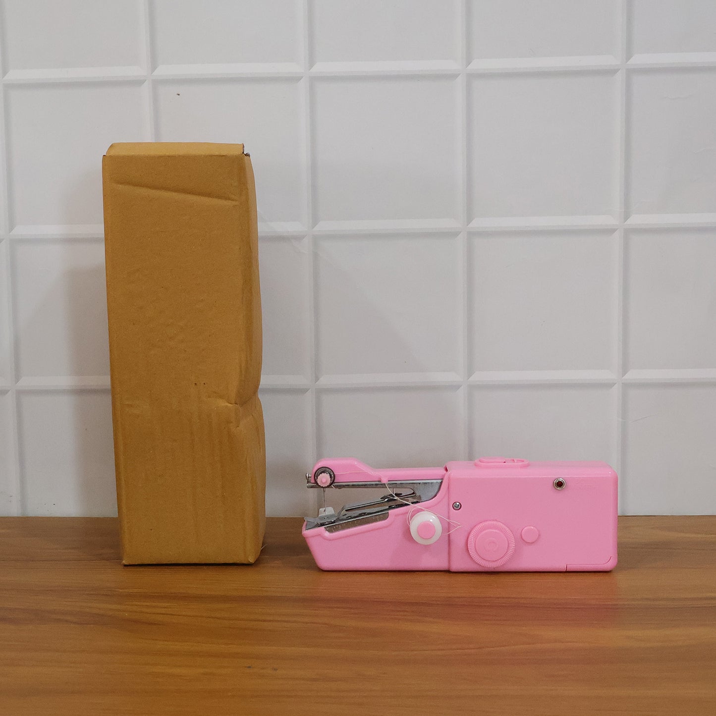 Portable handheld sewing machine by Wukusy with compact design, featuring a handle and sewing needle for on-the-go sewing projects.