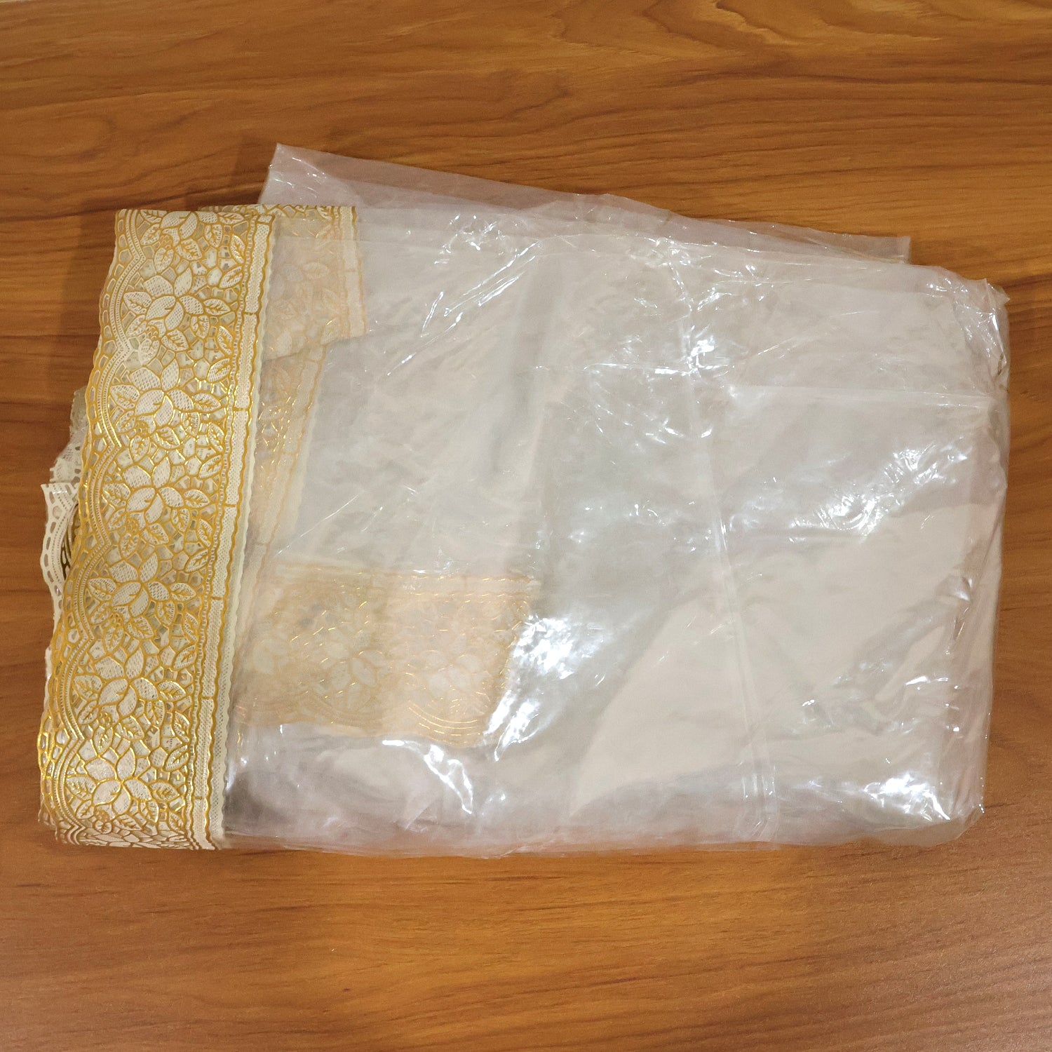 Clear PVC table cover measuring 87x59 inches from Wukusy, showing a smooth, transparent protective surface on a dining table.