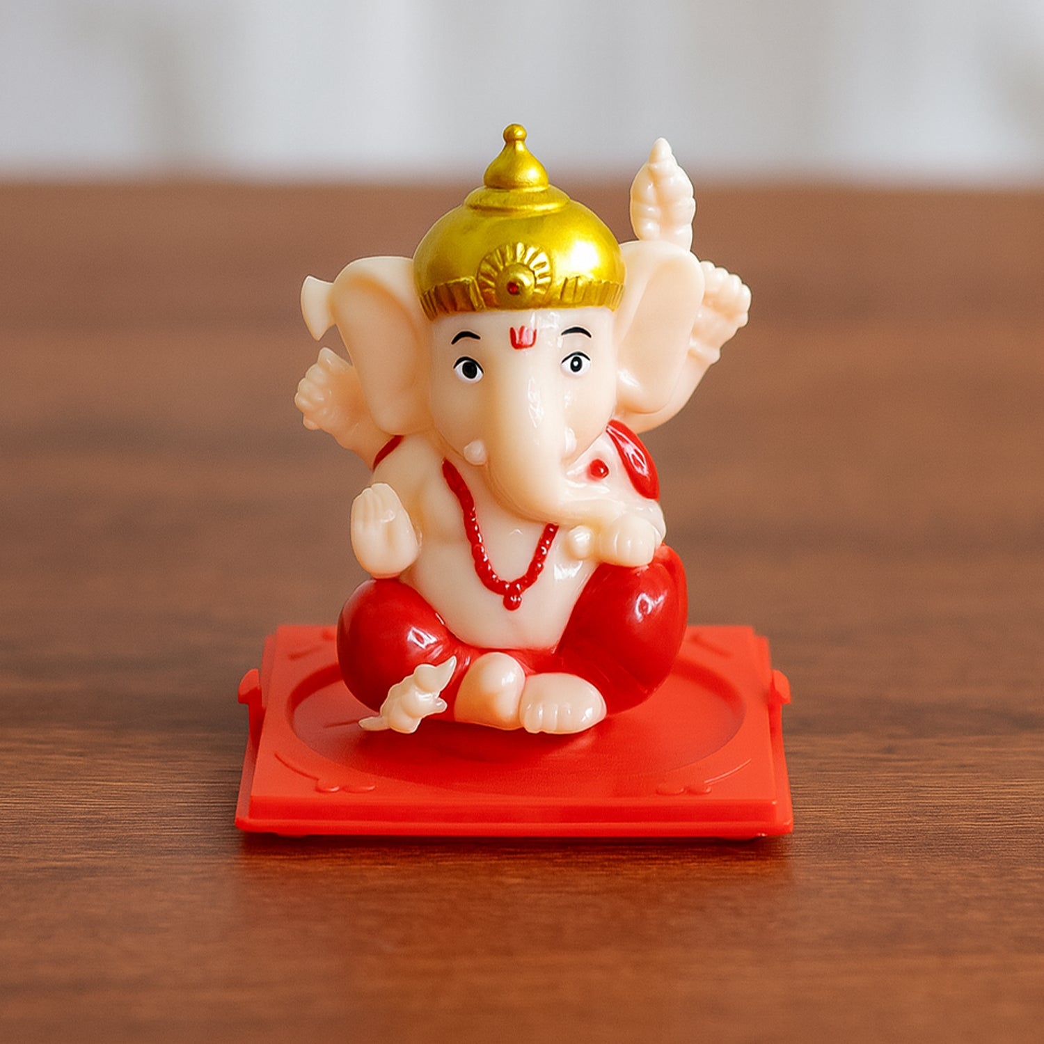 Small Lord Ganesh idol in transparent display case, ideal for home decor, by Wukusy, showcasing detailed craftsmanship.