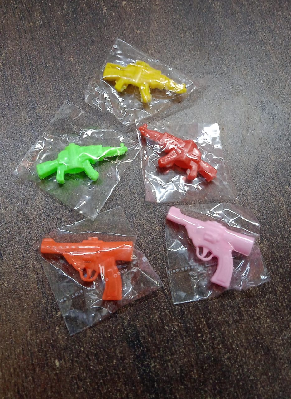 Colorful gun-shaped pencil top toy for kids, designed by Wukusy, featuring a small gun design in mixed bright colors.
