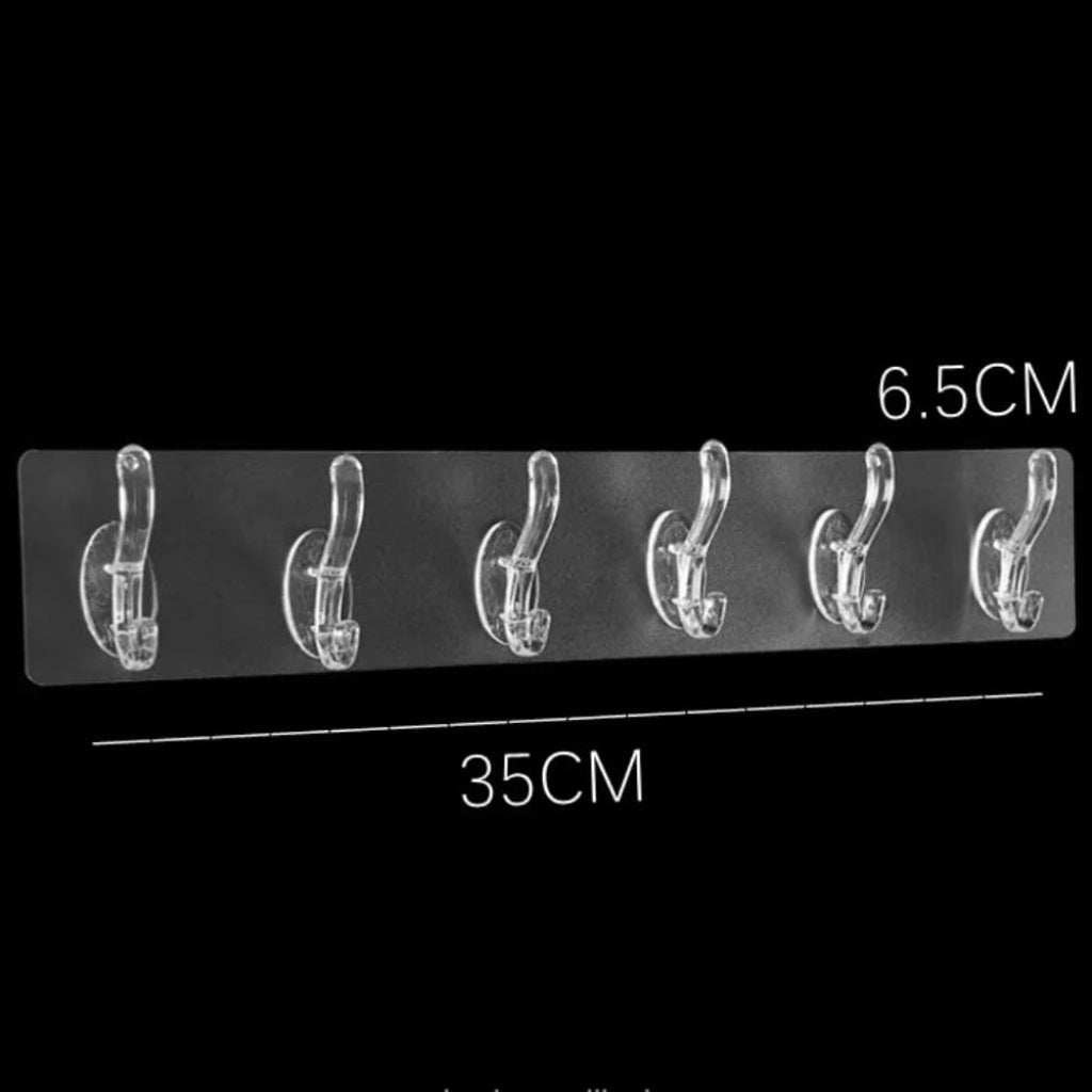 Six white self-adhesive hook stickers from FIZZI SHOP attached to a wall, suitable for hanging lightweight items.