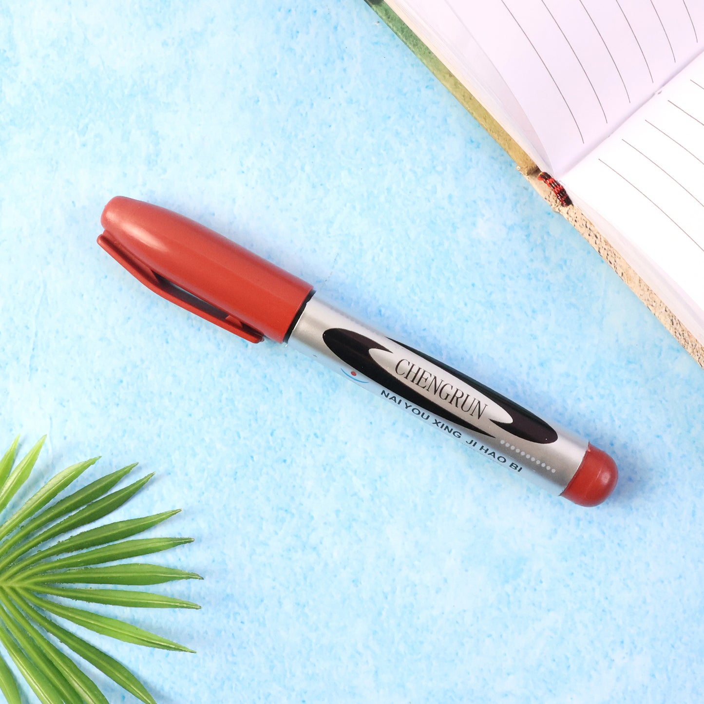 Maroon Wukusy premium permanent marker pen with fine tip on white background, showcasing the pen's color and design.