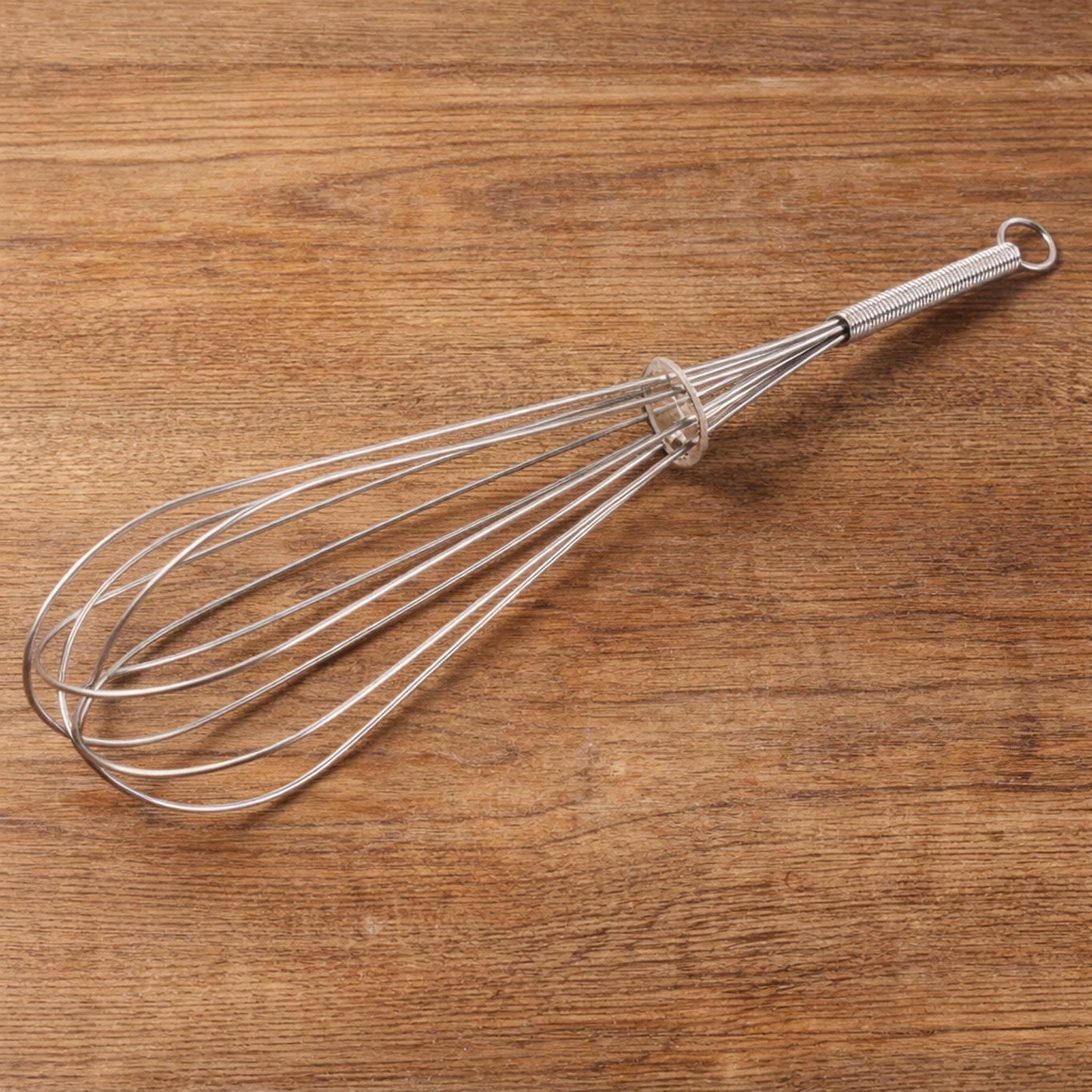 Manual stainless-steel egg beater whisk by Wukusy, showing the sleek, durable handle and wire beaters for mixing eggs and batter.