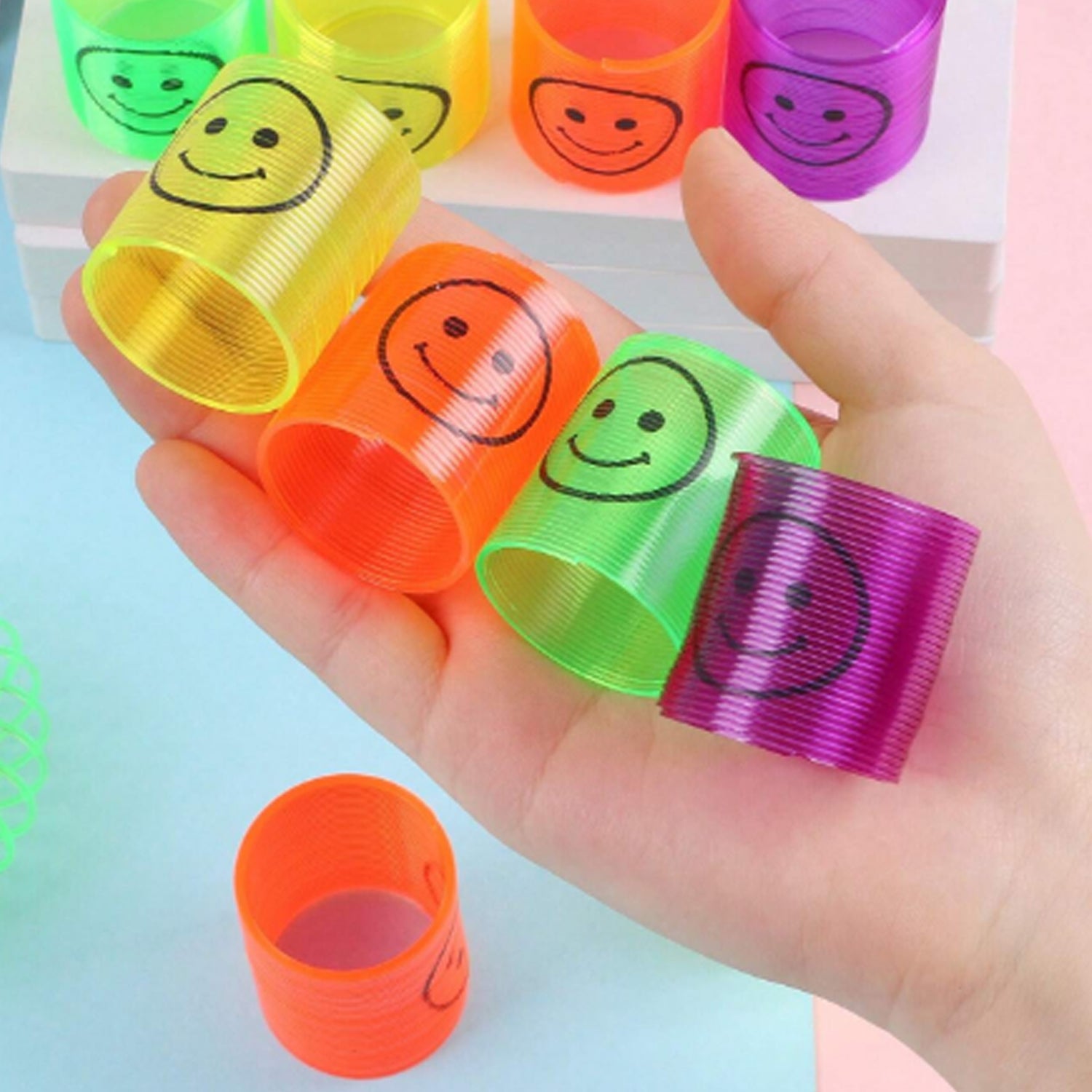 Set of 12 multicolor Wukusy magic smiley spring toys, compact, portable, and fun for kids to play with and carry easily.